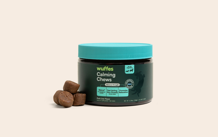 Container of Wuffes Calming Chews with four brown chew pieces beside it on a light background
