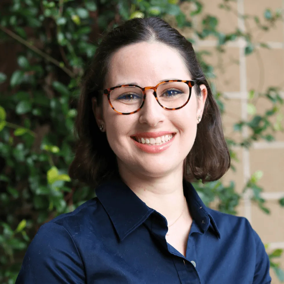 Dr. Erin Miscioscia, a Wuffes veterinary advisor, photographed outdoors in a dark blue shirt and glasses