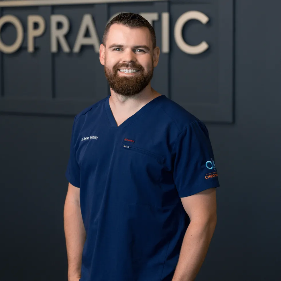 Dr. Joren Whitley, a Wuffes veterinary advisor, in navy scrubs at his animal chiropractic clinic