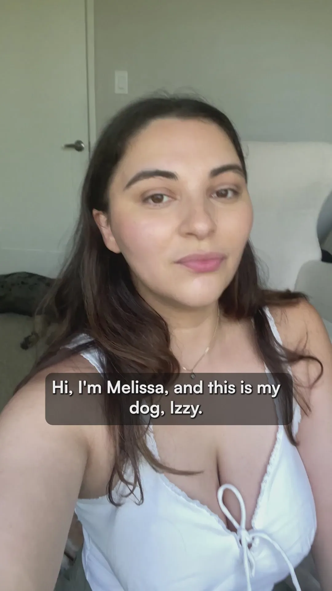 A woman named Melissa introducing herself and her dog, Izzy, to camera at home